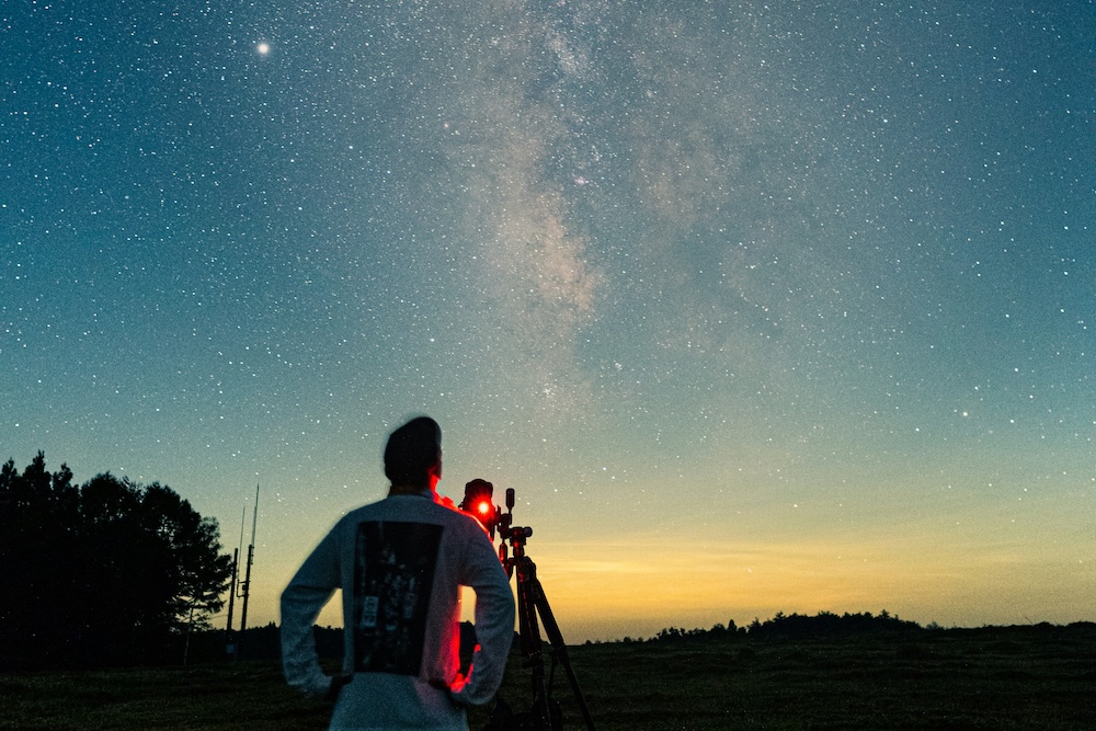 Man with telescope looking at stars