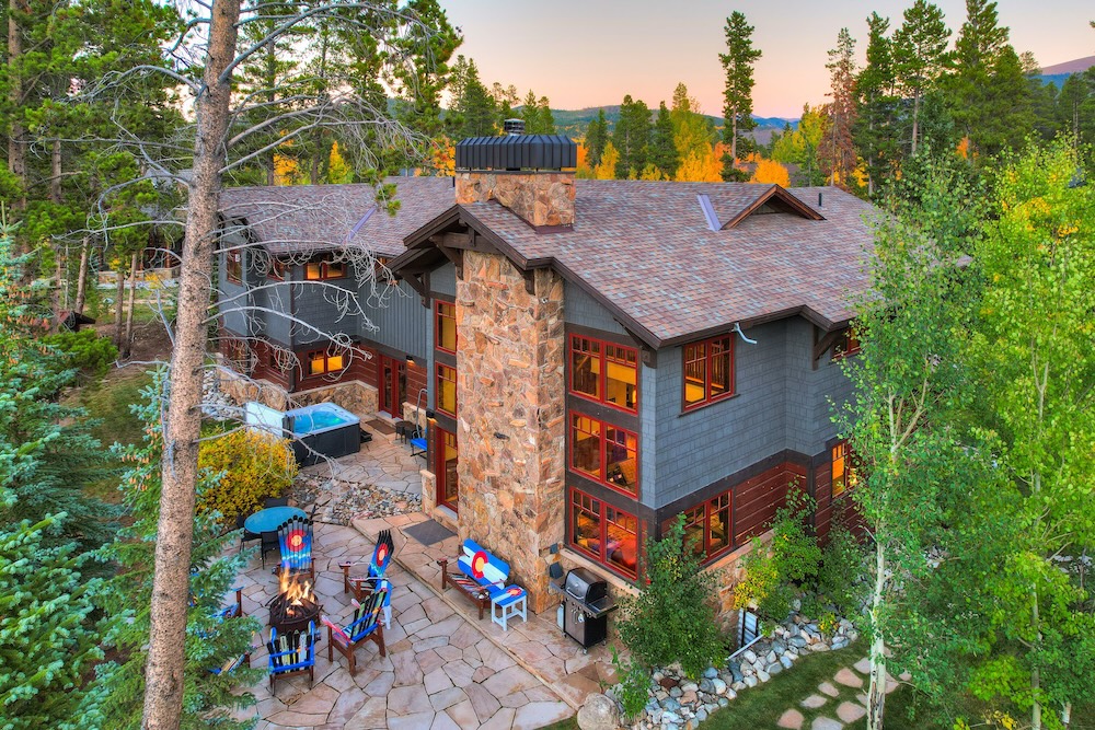 Vacation rental exterior with hot tub, fire pit, and fall foliage surroundings