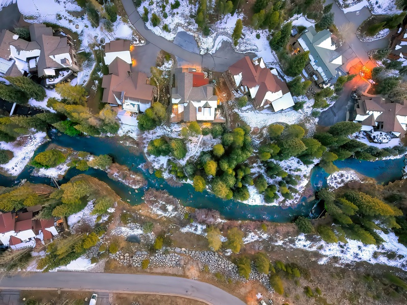 dos esquiadores suben a un remonte en un día despejado, con la pista cubierta de nieve debajo de ellos
