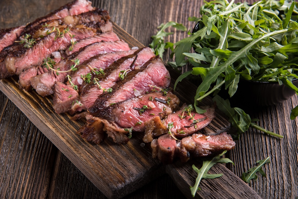 Sliced ribeye steak on a cutting board
