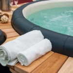 Towels rolled up and sitting next to a hot tub