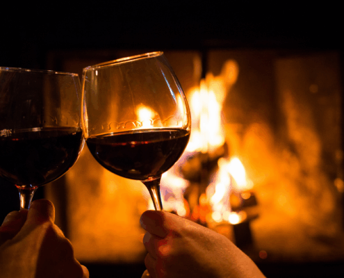 toasting wine in front of fireplace