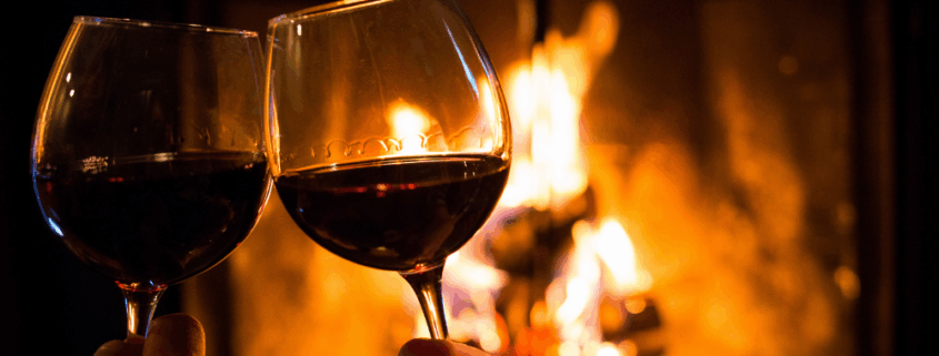 toasting wine in front of fireplace